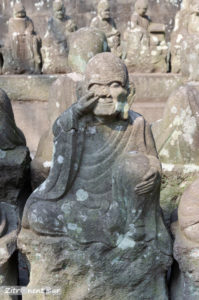 Statue eines in der Nase bohrenden Buddha im Garten Gohyaku Rakan